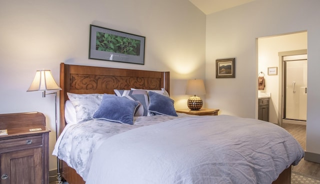 281 W Nicklaus Ave, Kalispell, MT 59901 - bedroom featuring wood finished floors, ensuite bathroom, and lofted ceiling