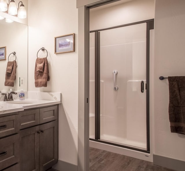 281 W Nicklaus Ave, Kalispell, MT 59901 - bathroom featuring vanity, a shower stall, and wood finished floors