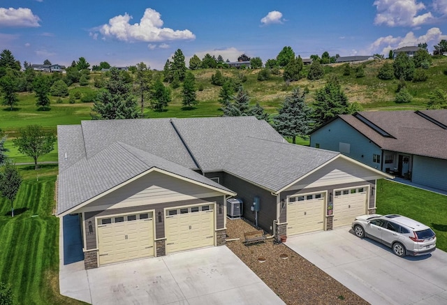 281 W Nicklaus Ave, Kalispell, MT 59901 - view of front facade with driveway, a garage, stone siding, and a front lawn