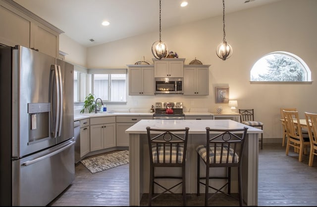 281 W Nicklaus Ave, Kalispell, MT 59901 - kitchen with appliances with stainless steel finishes, vaulted ceiling, light countertops, a center island, and a breakfast bar area