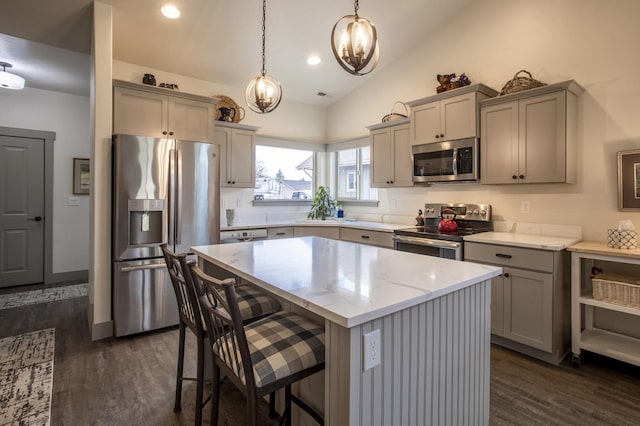 281 W Nicklaus Ave, Kalispell, MT 59901 - kitchen featuring stainless steel appliances, gray cabinetry, light stone counters, dark wood finished floors, and vaulted ceiling