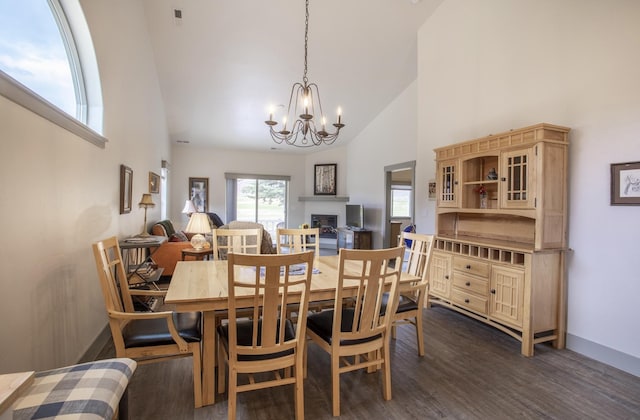 281 W Nicklaus Ave, Kalispell, MT 59901 - dining space featuring high vaulted ceiling, a chandelier, dark wood-style flooring, and a fireplace