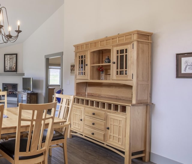 281 W Nicklaus Ave, Kalispell, MT 59901 - dining room featuring a chandelier, a glass covered fireplace, high vaulted ceiling, and dark wood-type flooring