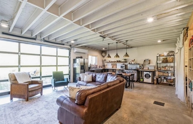 1210 Grand Fir Rd, Bigfork, MT 59911 - living area featuring an AC wall unit, concrete floors, and plenty of natural light