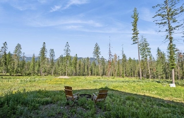 1210 Grand Fir Rd, Bigfork, MT 59911 - view of yard featuring a view of trees and an outdoor fire pit
