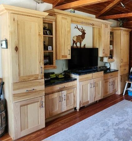 6570 Blossburg Rd, Canyon Creek, MT 59633 - kitchen with a wood ceiling with exposed beams, dark wood-style floors, dark countertops, light brown cabinetry, and open shelves