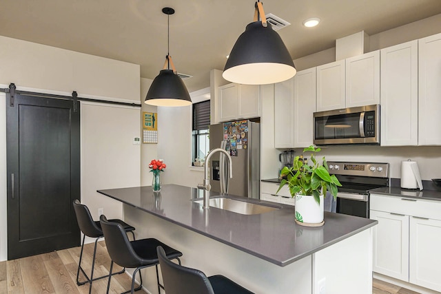 6170 Elysian Rd Unit 103-203, Billings, MT 59101 - kitchen featuring stainless steel appliances, dark countertops, white cabinets, a kitchen bar, and recessed lighting