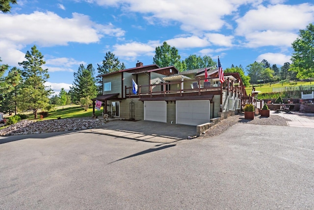 6350 S Meadowwood Ln, Missoula, MT 59803 - view of front facade featuring a chimney, driveway, and an attached garage