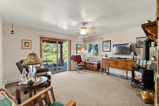 6350 S Meadowwood Ln, Missoula, MT 59803 - carpeted living room with a wood stove, a ceiling fan, and a textured ceiling