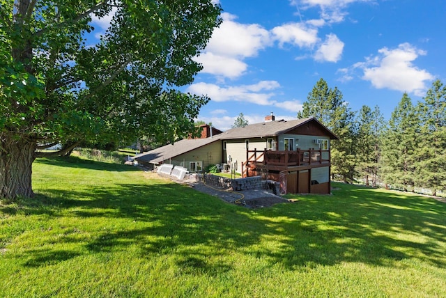 6350 S Meadowwood Ln, Missoula, MT 59803 - back of property with a deck, a lawn, and a chimney