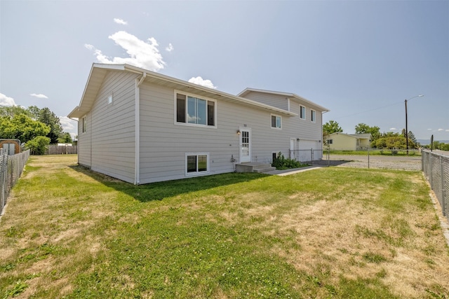 701 E Lewis St, East Helena, MT 59635 - rear view of property featuring a garage, driveway, and a fenced backyard