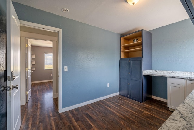 701 E Lewis St, East Helena, MT 59635 - unfurnished bedroom featuring dark wood finished floors and a textured wall