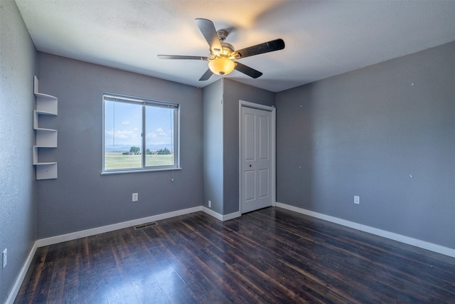 701 E Lewis St, East Helena, MT 59635 - unfurnished bedroom with dark wood-type flooring, a ceiling fan, and a closet
