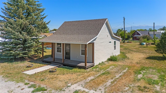 324 N Pine St, Townsend, MT 59644 - view of front facade with a shingled roof, a porch, and a front yard