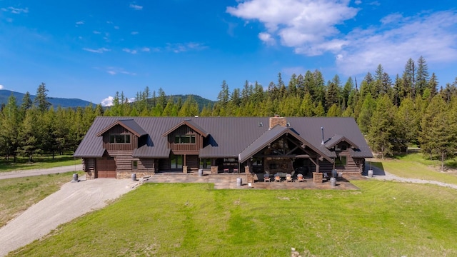 4475 Star Meadows Rd, Whitefish, MT 59937 - view of front of home with a front yard, stone siding, and a mountain view