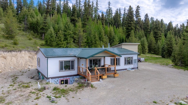 4475 Star Meadows Rd, Whitefish, MT 59937 - view of front of property featuring a metal roof, a forest view, and a deck