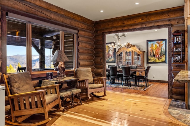 4475 Star Meadows Rd, Whitefish, MT 59937 - sitting room featuring wood-type flooring, rustic walls, recessed lighting, a chandelier, and a mountain view