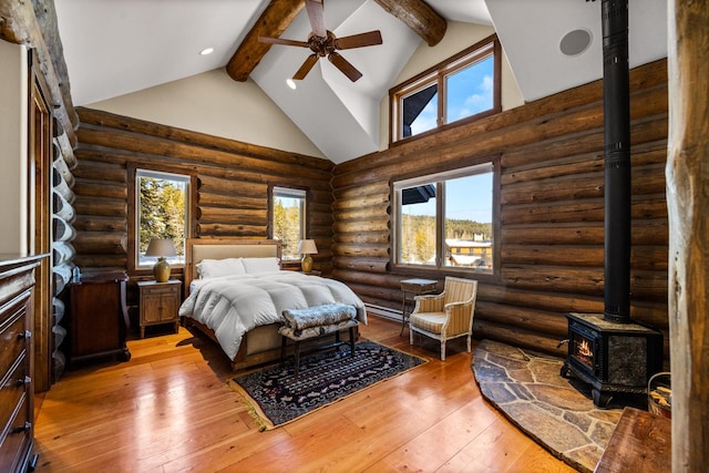 4475 Star Meadows Rd, Whitefish, MT 59937 - bedroom featuring a wood stove, beam ceiling, high vaulted ceiling, log walls, and light wood finished floors