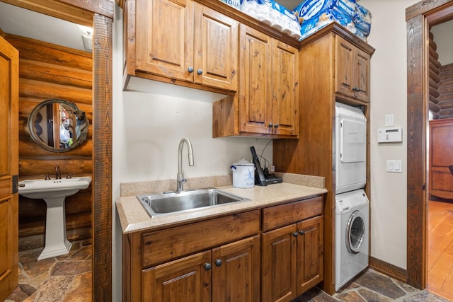 4475 Star Meadows Rd, Whitefish, MT 59937 - kitchen featuring stacked washer and clothes dryer, log walls, dark stone finish flooring, light countertops, and brown cabinets
