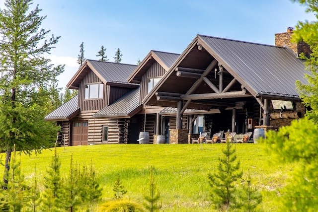 4475 Star Meadows Rd, Whitefish, MT 59937 - rear view of property featuring log exterior, a metal roof, board and batten siding, a chimney, and a yard
