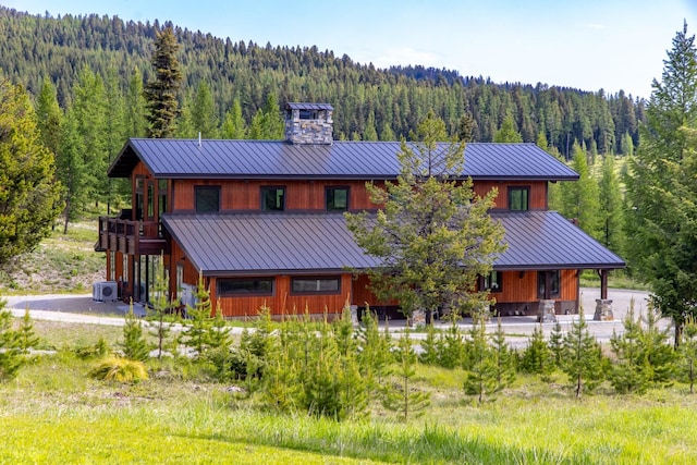 4475 Star Meadows Rd, Whitefish, MT 59937 - rear view of property featuring a wooded view, a metal roof, a chimney, and a standing seam roof