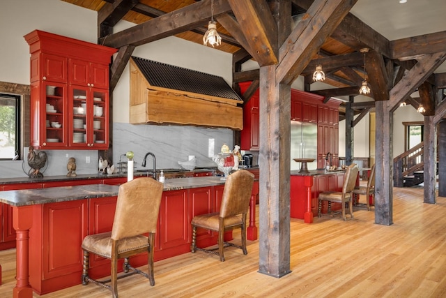 4475 Star Meadows Rd, Whitefish, MT 59937 - kitchen with reddish brown cabinets, decorative backsplash, light wood-style floors, dark countertops, and wooden ceiling