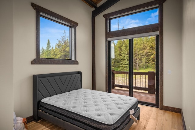 4475 Star Meadows Rd, Whitefish, MT 59937 - bedroom featuring access to exterior, wood finished floors, and vaulted ceiling