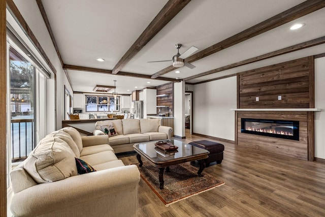 4475 Star Meadows Rd, Whitefish, MT 59937 - living room featuring a glass covered fireplace, recessed lighting, wood finished floors, beam ceiling, and a ceiling fan