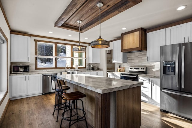 4475 Star Meadows Rd, Whitefish, MT 59937 - kitchen featuring stainless steel appliances, decorative backsplash, white cabinetry, hardwood / wood-style floors, and recessed lighting