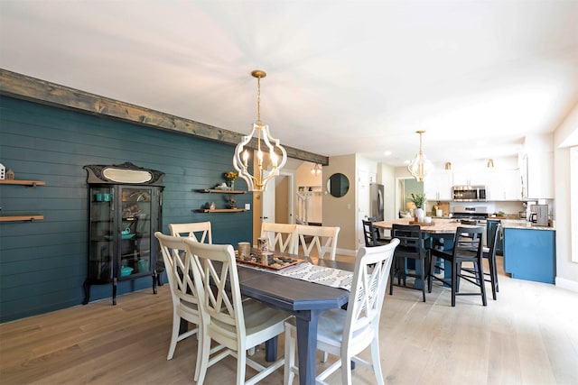 108 Apple House Ln, Missoula, MT 59802 - dining room with a chandelier, light wood-type flooring, and wood walls