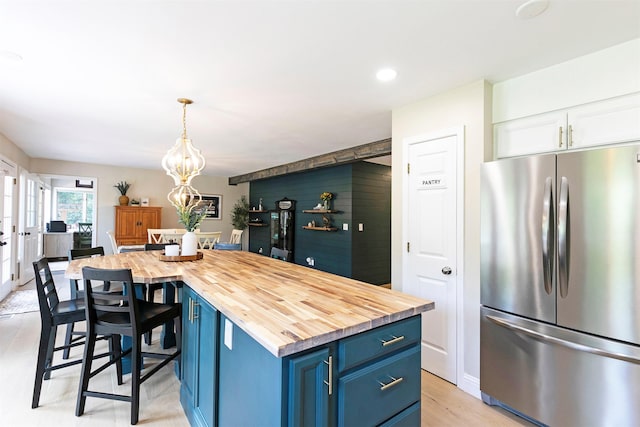 108 Apple House Ln, Missoula, MT 59802 - kitchen featuring freestanding refrigerator, blue cabinetry, butcher block countertops, a chandelier, and white cabinetry
