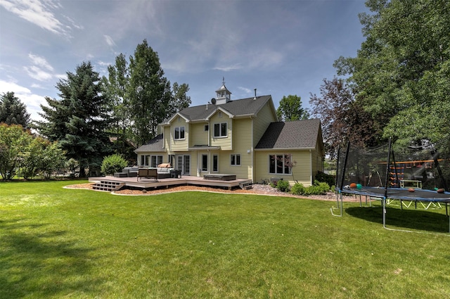 108 Apple House Ln, Missoula, MT 59802 - back of house featuring a trampoline, a wooden deck, an outdoor living space, and a yard