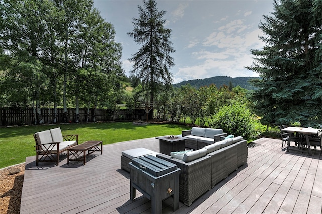 108 Apple House Ln, Missoula, MT 59802 - wooden deck featuring an outdoor living space with a fire pit, a fenced backyard, a mountain view, and outdoor dining area