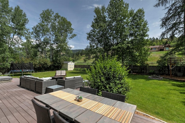 108 Apple House Ln, Missoula, MT 59802 - wooden terrace with a trampoline, a shed, a fenced backyard, and an outdoor hangout area
