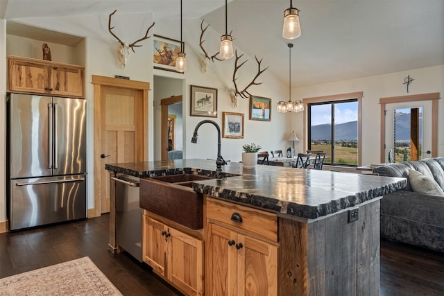 559 Stage Springs Ln, Stevensville, MT 59870 - kitchen featuring appliances with stainless steel finishes, open floor plan, vaulted ceiling, dark wood-style floors, and hanging light fixtures