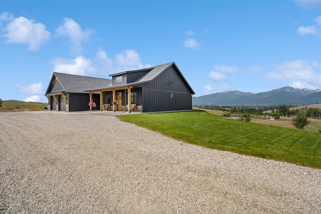 559 Stage Springs Ln, Stevensville, MT 59870 - modern farmhouse featuring driveway, a front yard, a garage, a mountain view, and board and batten siding