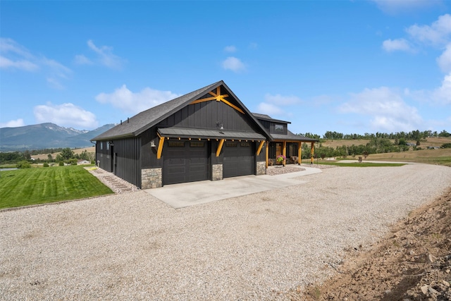 559 Stage Springs Ln, Stevensville, MT 59870 - view of home's exterior with driveway, stone siding, a mountain view, a lawn, and an attached garage