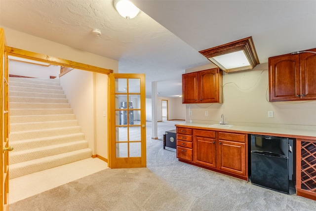 46452 Stagecoach Trl, Ronan, MT 59864 - kitchen with refrigerator, light colored carpet, light countertops, and brown cabinets
