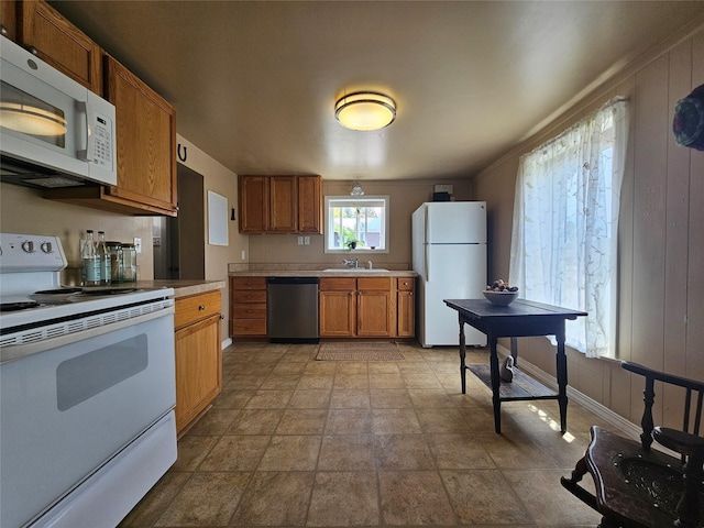 102 E Chilton St, White Sulphur Springs, MT 59645 - kitchen featuring white appliances, light countertops, brown cabinets, and stone finish floors