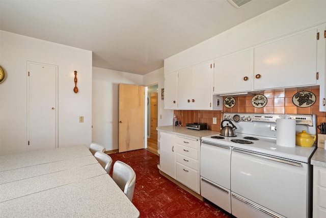 209 Spruce St, Anaconda, MT 59711 - kitchen with white electric range oven, tasteful backsplash, light countertops, white cabinets, and dark flooring