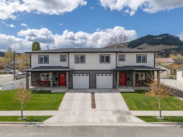 605-607 Leslie Ave, Helena, MT 59601 - view of front facade featuring a porch, driveway, a garage, a mountain view, and stone siding