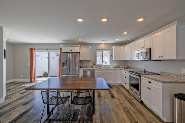 605-607 Leslie Ave, Helena, MT 59601 - kitchen with stainless steel appliances, white cabinets, wood finished floors, recessed lighting, and light stone countertops