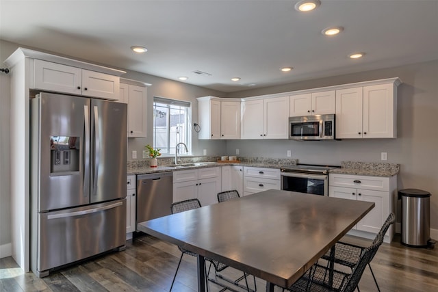 605-607 Leslie Ave, Helena, MT 59601 - kitchen with stainless steel appliances, white cabinetry, dark wood finished floors, light stone counters, and recessed lighting