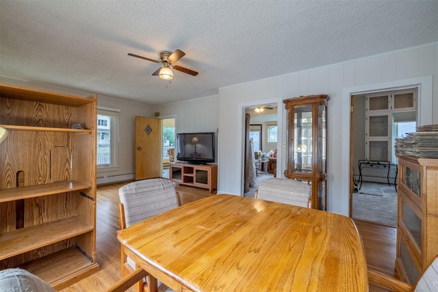 1414 Boulder Ave, Helena, MT 59601 - dining room with ceiling fan, baseboard heating, a textured ceiling, and wood finished floors