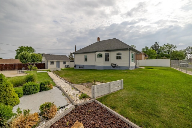 1414 Boulder Ave, Helena, MT 59601 - rear view of property featuring a garden, a fenced backyard, a chimney, and a shingled roof