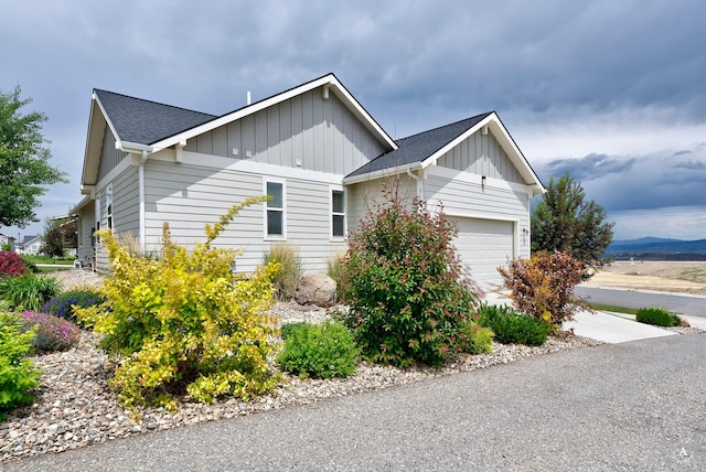 2871 Alexis Ave, Helena, MT 59601 - view of side of home with board and batten siding, an attached garage, and roof with shingles