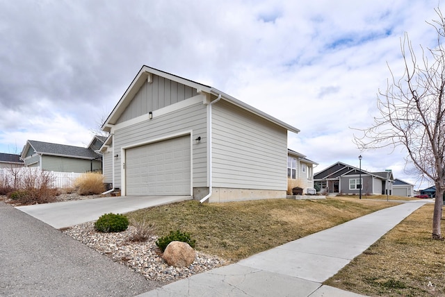 2871 Alexis Ave, Helena, MT 59601 - view of side of property featuring driveway, board and batten siding, an attached garage, and a lawn