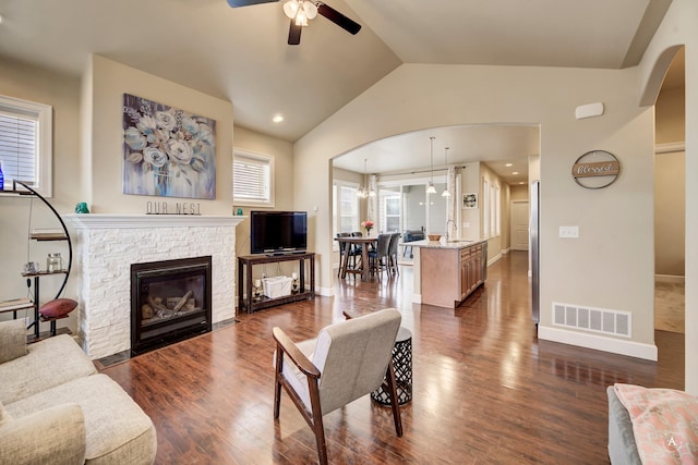 2871 Alexis Ave, Helena, MT 59601 - living area featuring a ceiling fan, vaulted ceiling, a fireplace, dark wood-type flooring, and arched walkways