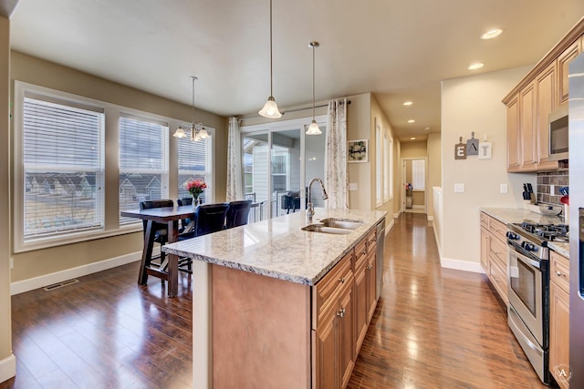 2871 Alexis Ave, Helena, MT 59601 - kitchen with stainless steel appliances, dark wood-type flooring, light stone counters, a chandelier, and decorative light fixtures