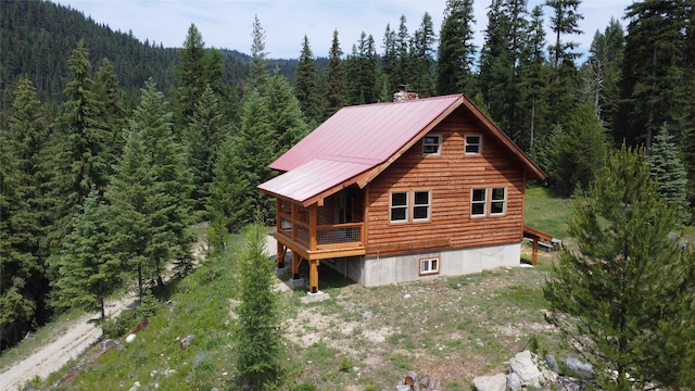 670GUSCREEK Gus Creek Rd, Yaak, MT 59935 - rear view of property with a forest view, a chimney, and a metal roof